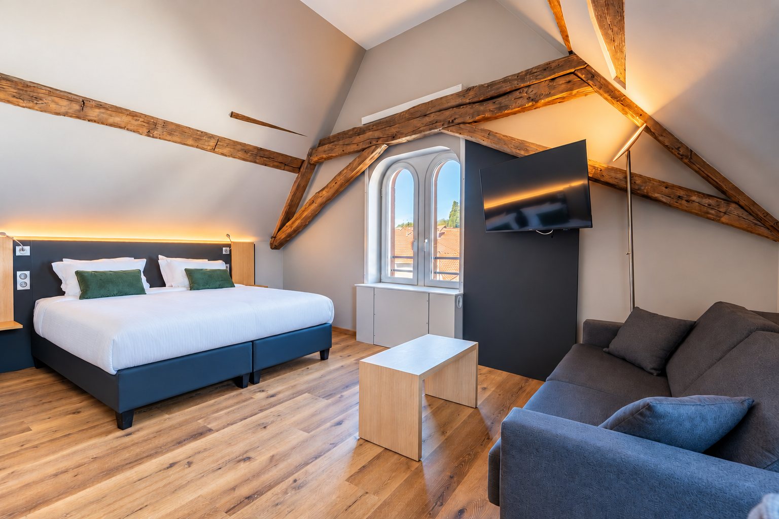 Junior suite Signature avec grand lit, canapé et charpente apparente